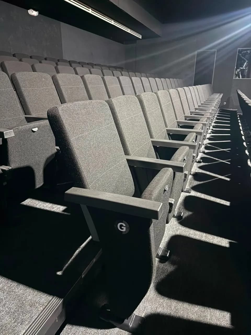 Fila de butacas de auditorio numeradas por letra