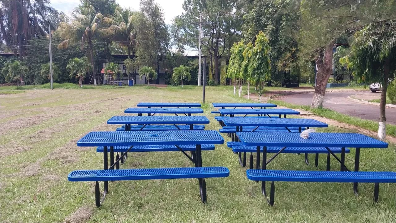 Mesas de picnic metálicas azules en el jardín