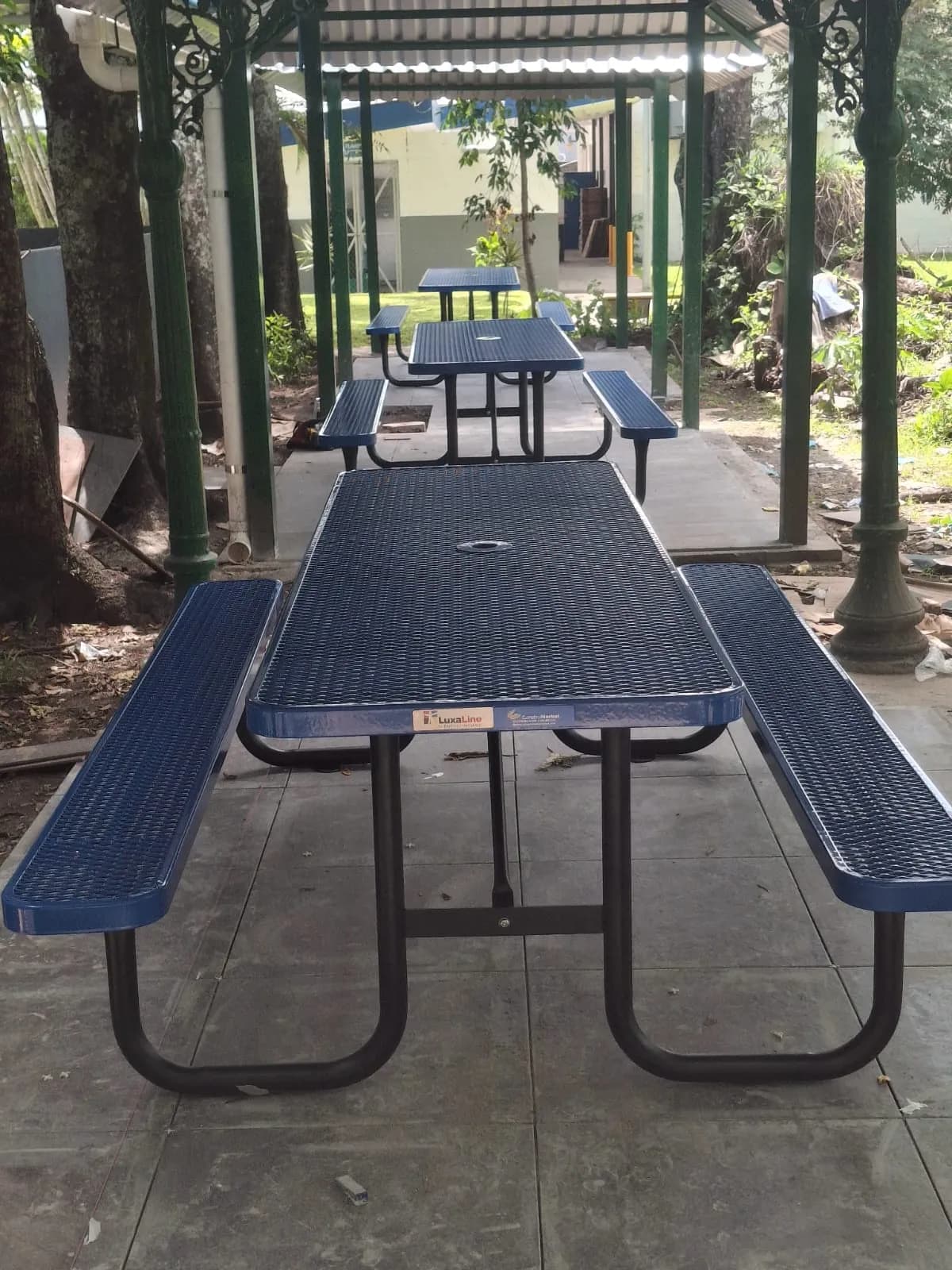 Mesa de picnic metálica LuxaLine bajo una pérgola