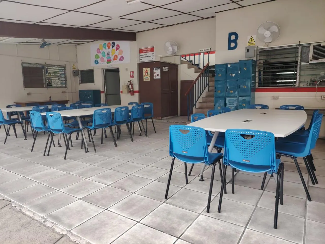 Comedor institucional con mesas y sillas azules