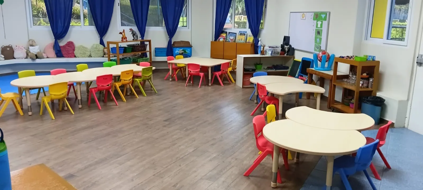 Aula de preescolar con mesas modulares y sillas de colores