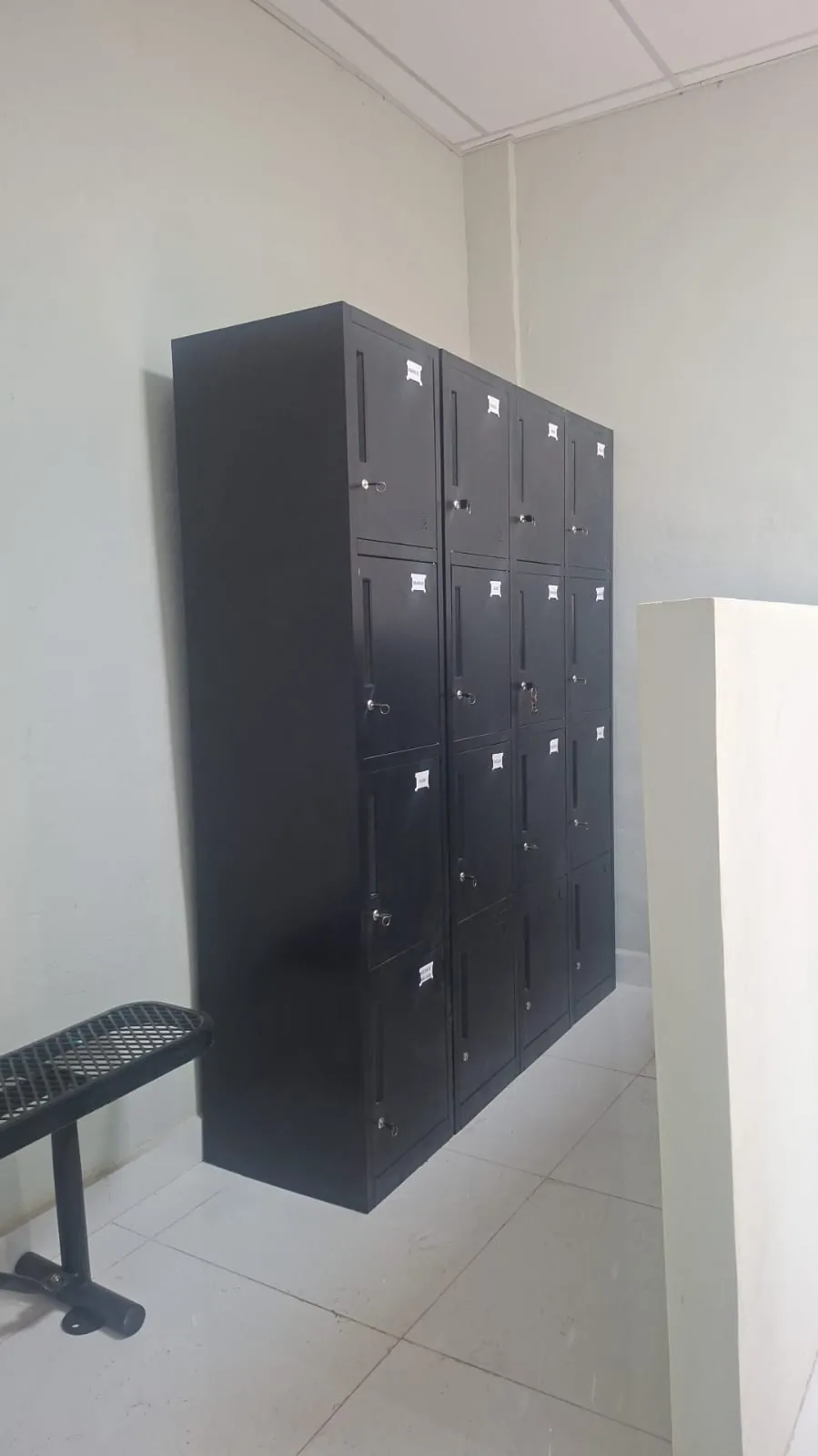 Four-tier metal lockers installed next to a bench
