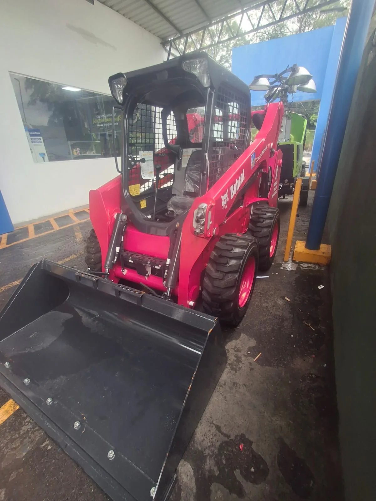 Pink Bobcat skid-steer loader seen from the front, with its black bucket and pink rims