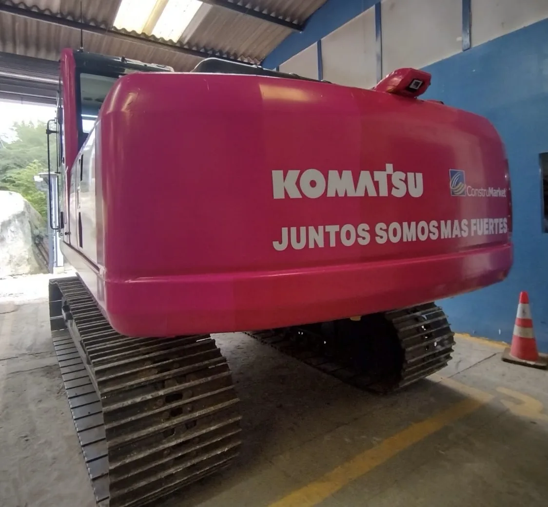 Parte trasera de una excavadora Komatsu de color rosa con el mensaje «Juntos somos más fuertes»