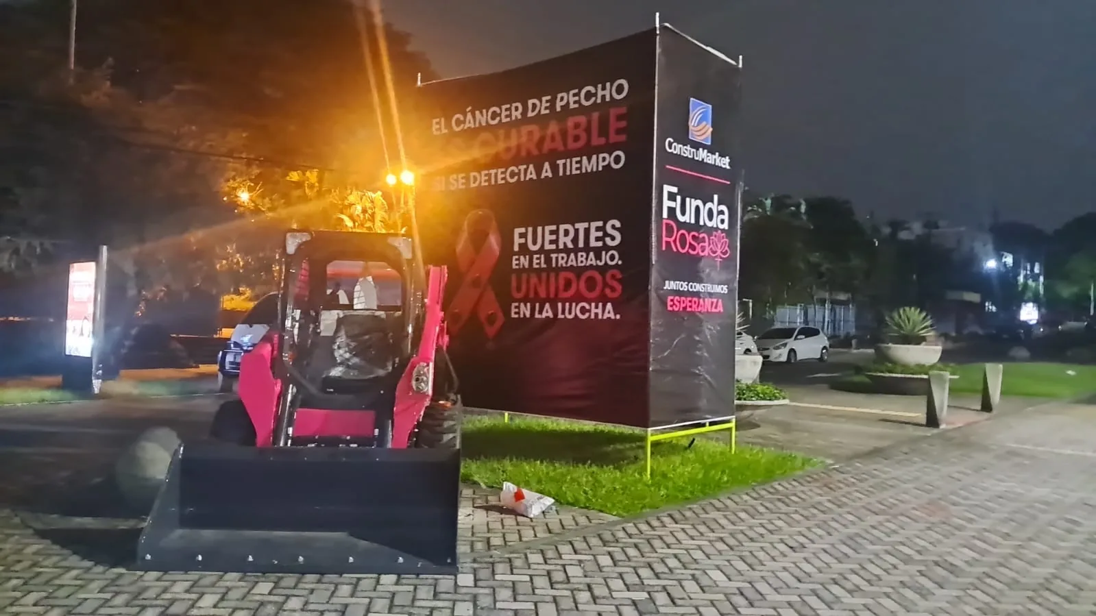 Pink Bobcat skid-steer loader next to a black banner reading “Breast cancer is curable when detected early” with the FundaRosa logo