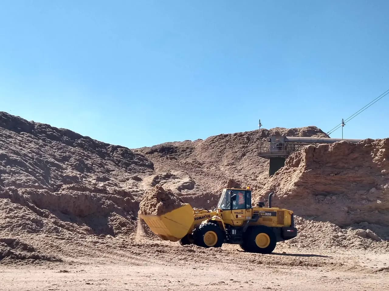 Cargador Komatsu WA320-6 con balde de 5 m³ levantando bagazo en el patio de un ingenio azucarero